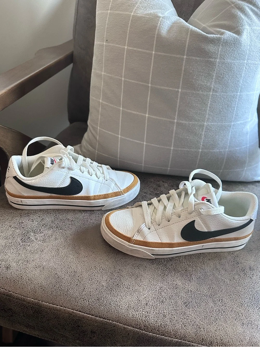 Nike Womans White Leather Low-Top Sneakers with Black Swoosh and Tan Accent.